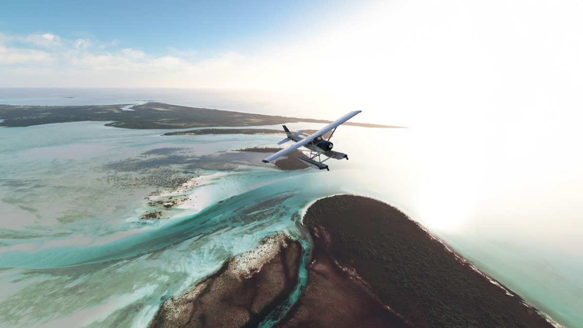 A small floatplane flying over cays and turquoise shallows